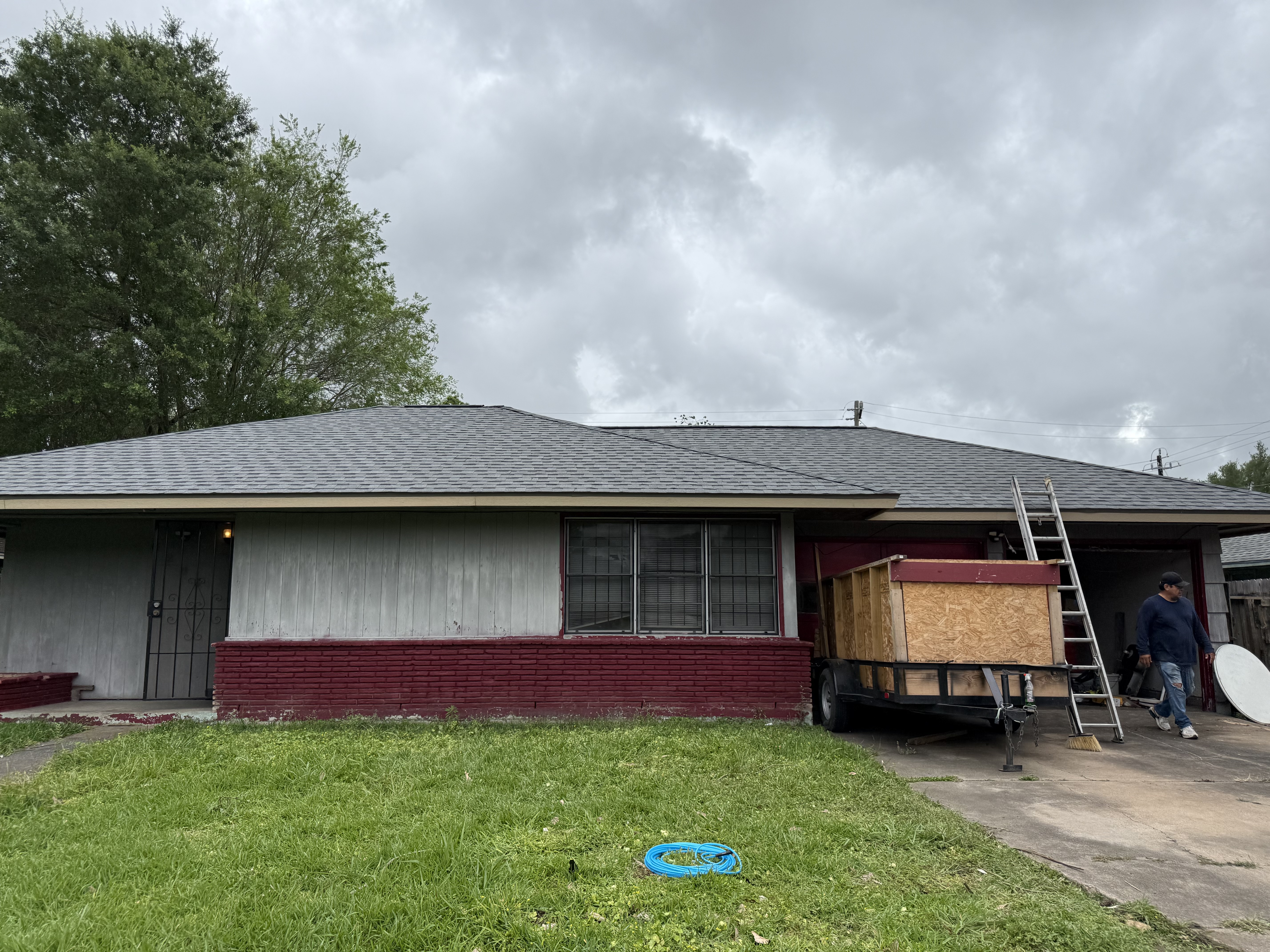 New charcoal shingle roof installed on a Houston home with painted brick exterior