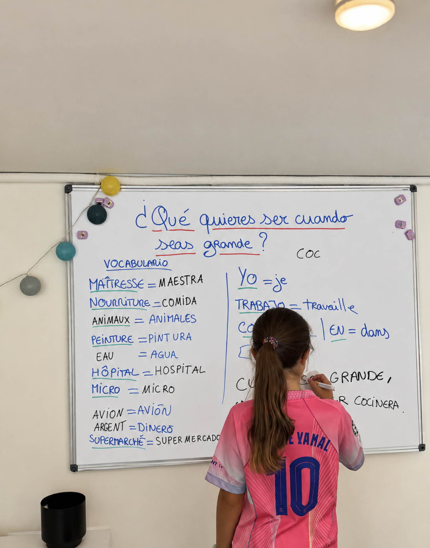 Enfant écrivant du vocabulaire en espagnol au tableau blanc