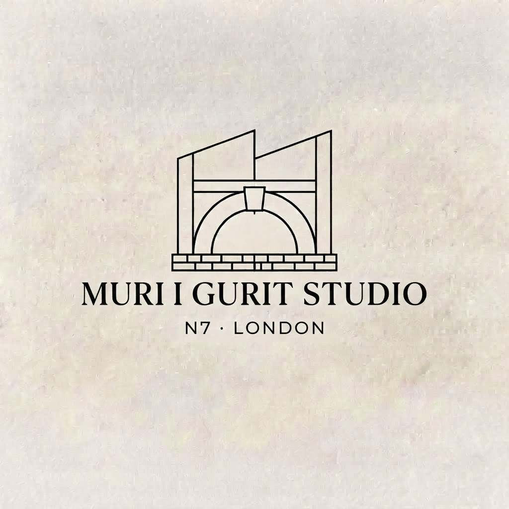 Studio workspace with architectural drawings and stone samples on oak table