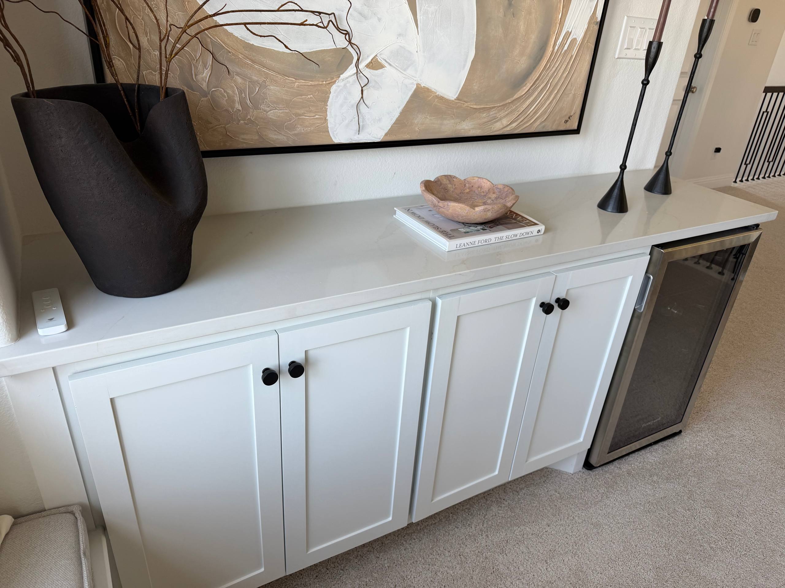 White shaker built-in cabinet with marble countertop, black hardware and integrated wine refrigerator