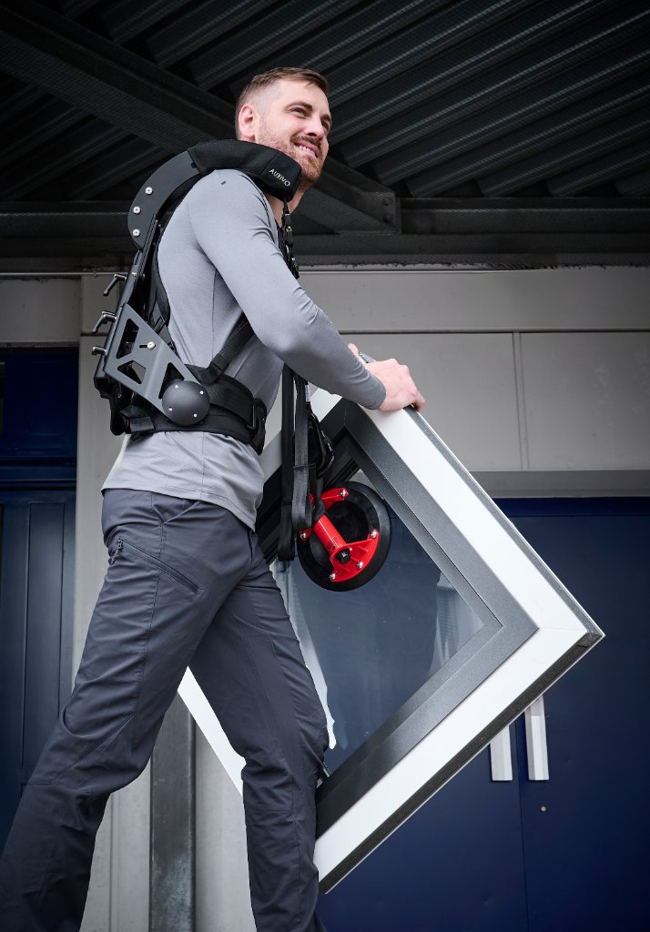Medewerker draagt een raamframe met de CarrySuit en een zuigmokop