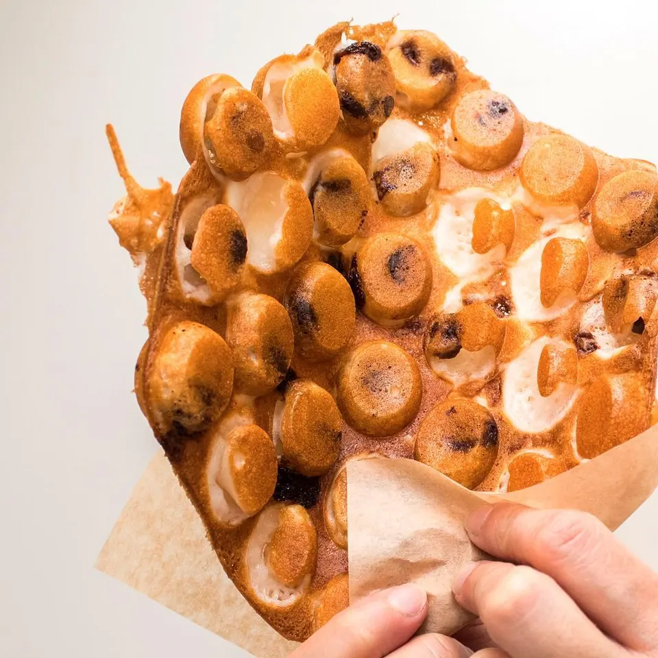 A Muffle pulled apart to show its chewy centre and chocolate chips