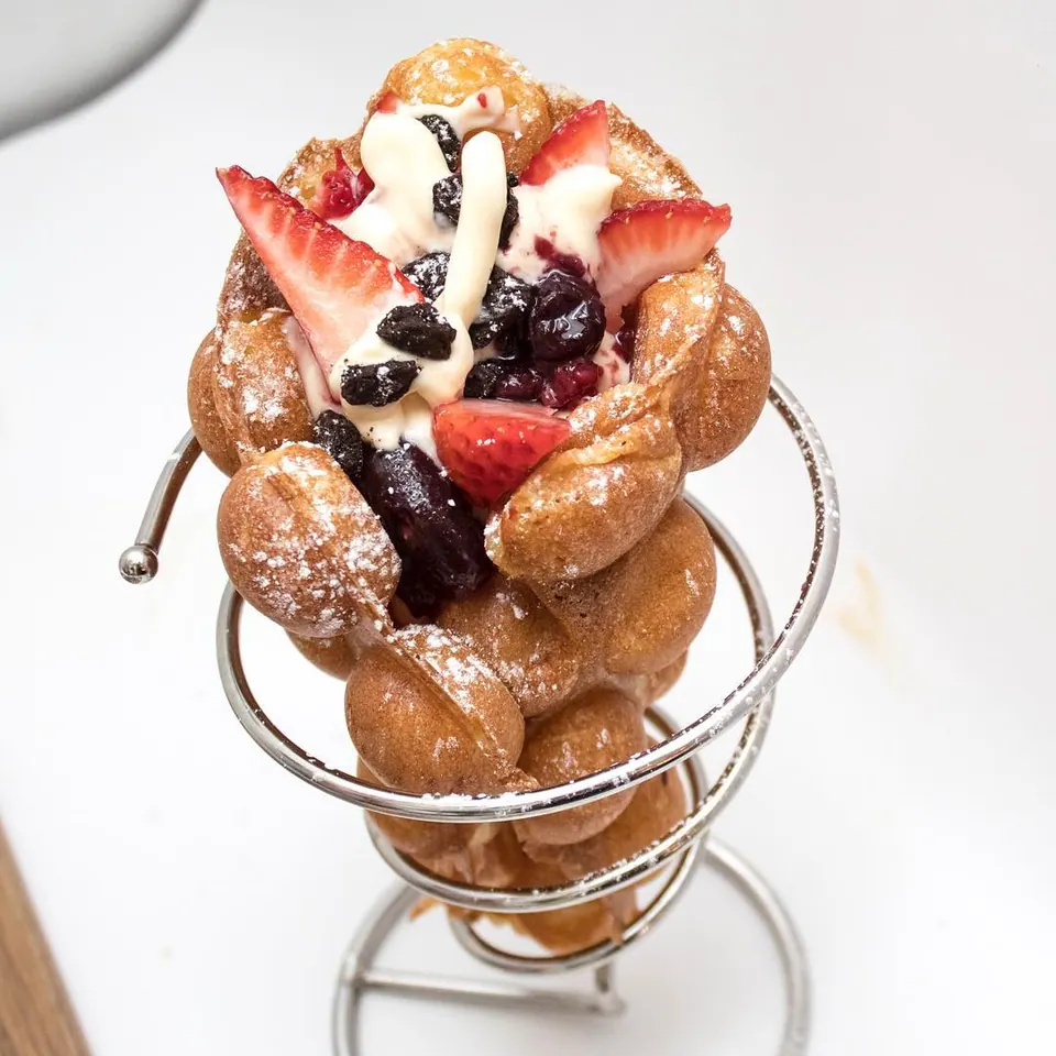 A golden Muffle filled with strawberries, berries and cream