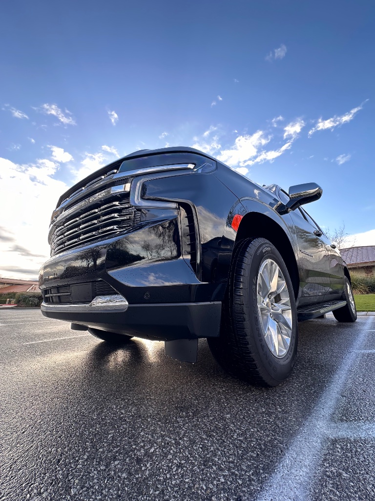 Black luxury SUV parked under blue sky