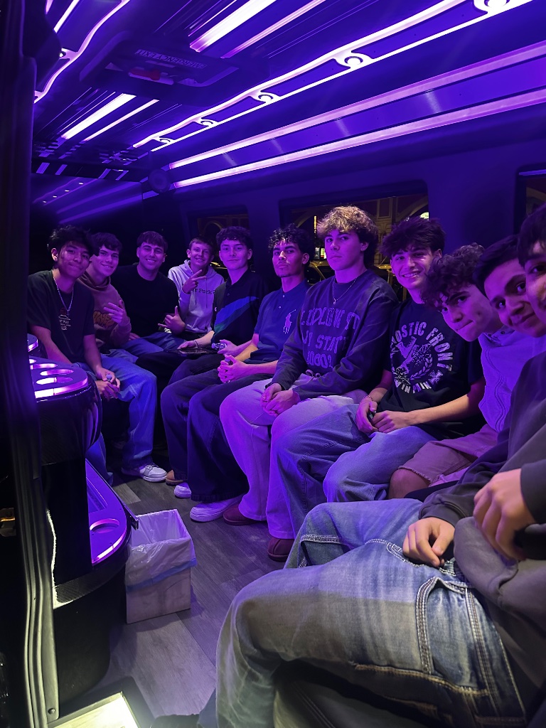 Group of friends inside Sprinter limo cabin with purple LED ambient lighting and bar