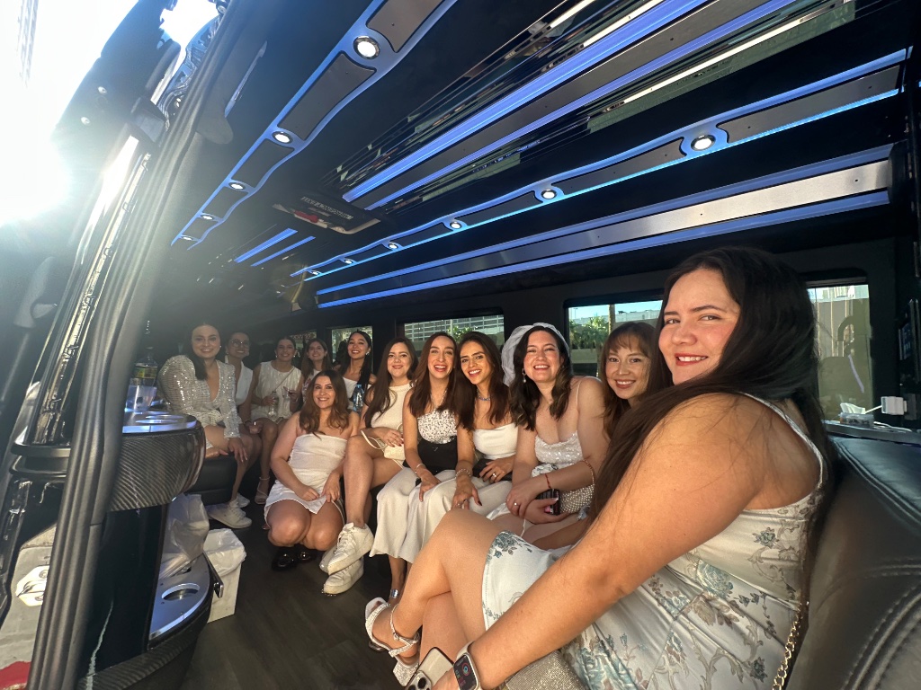 Bridal party seated inside Sprinter limo cabin with blue LED ambient lighting and bar