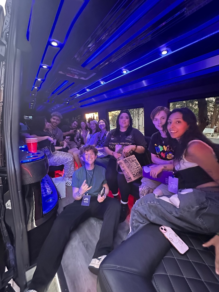 Group of friends inside Sprinter limo cabin with blue LED lighting and bar