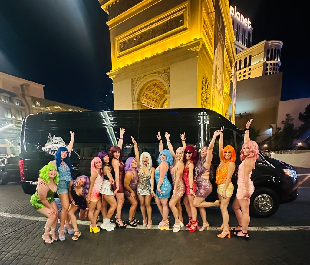 Bachelorette group of 14 posing in front of black Viva Limo Sprinter van on the Las Vegas Strip