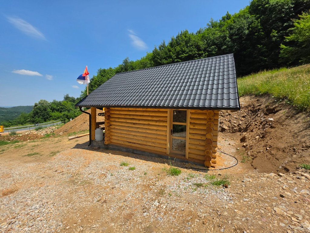 Završena brvnara — bočni pogled sa krovom i betonskom osnovom