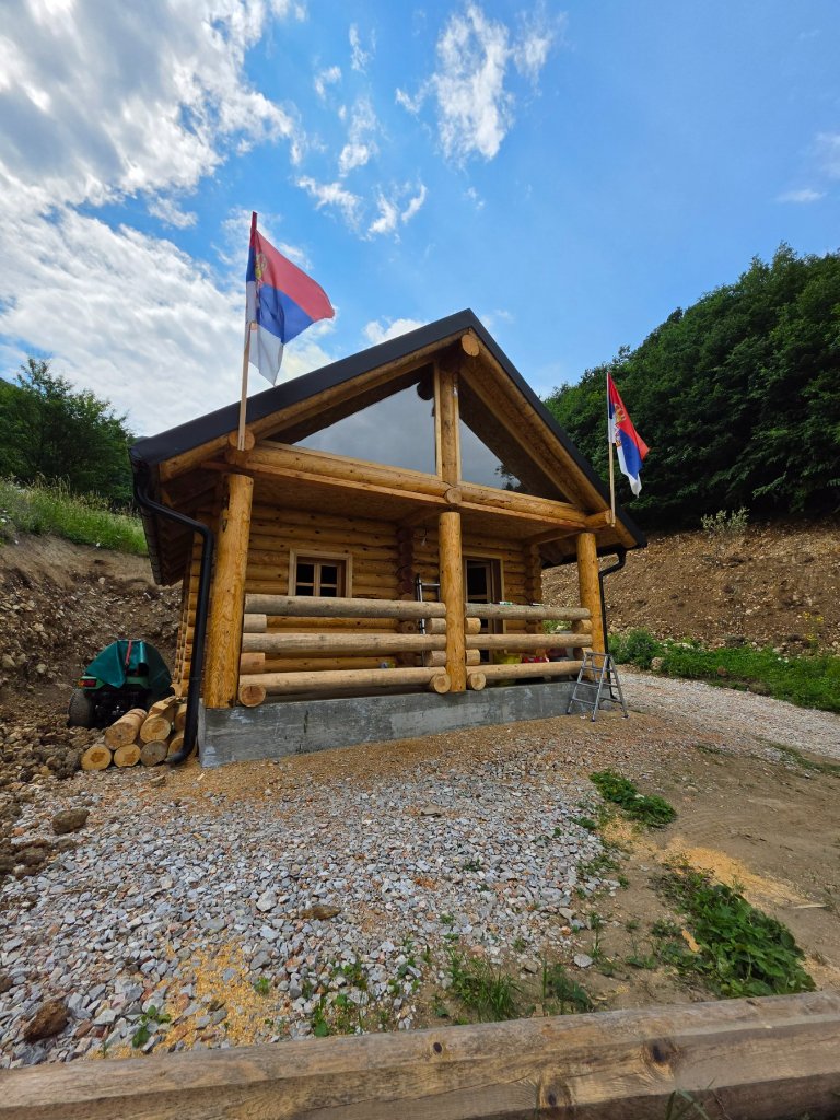 Završena brvnara — trem sa drvenom ogradom i panoramskim prozorom