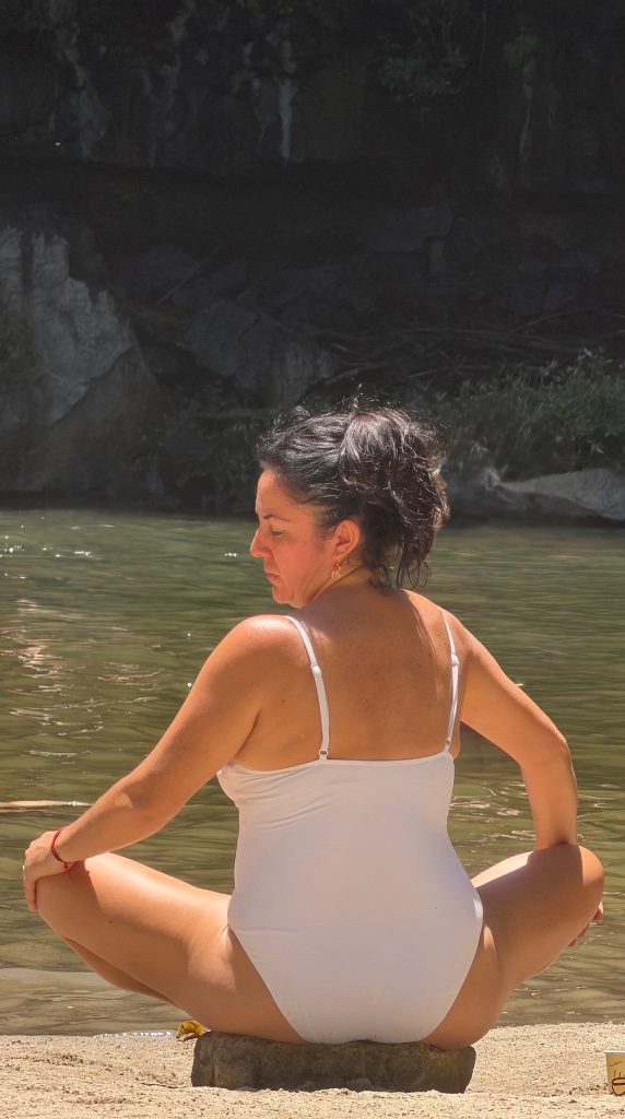 Woman meditating calmly by the water