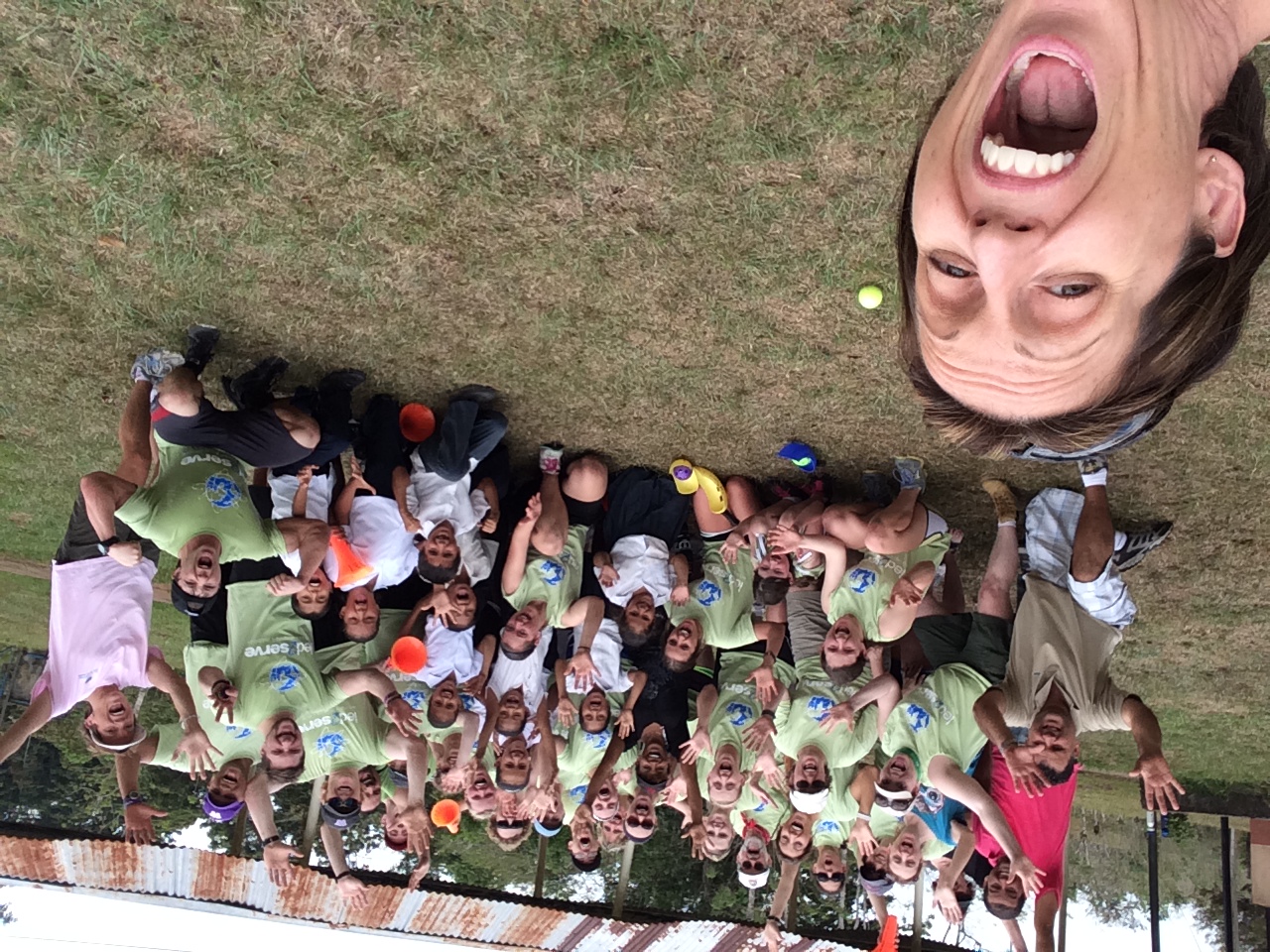 Group selfie with volunteers and children on a grassy field