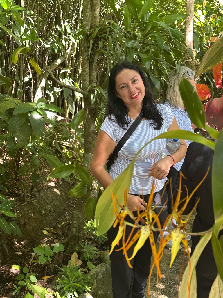 Woman among tropical orchids in the rainforest