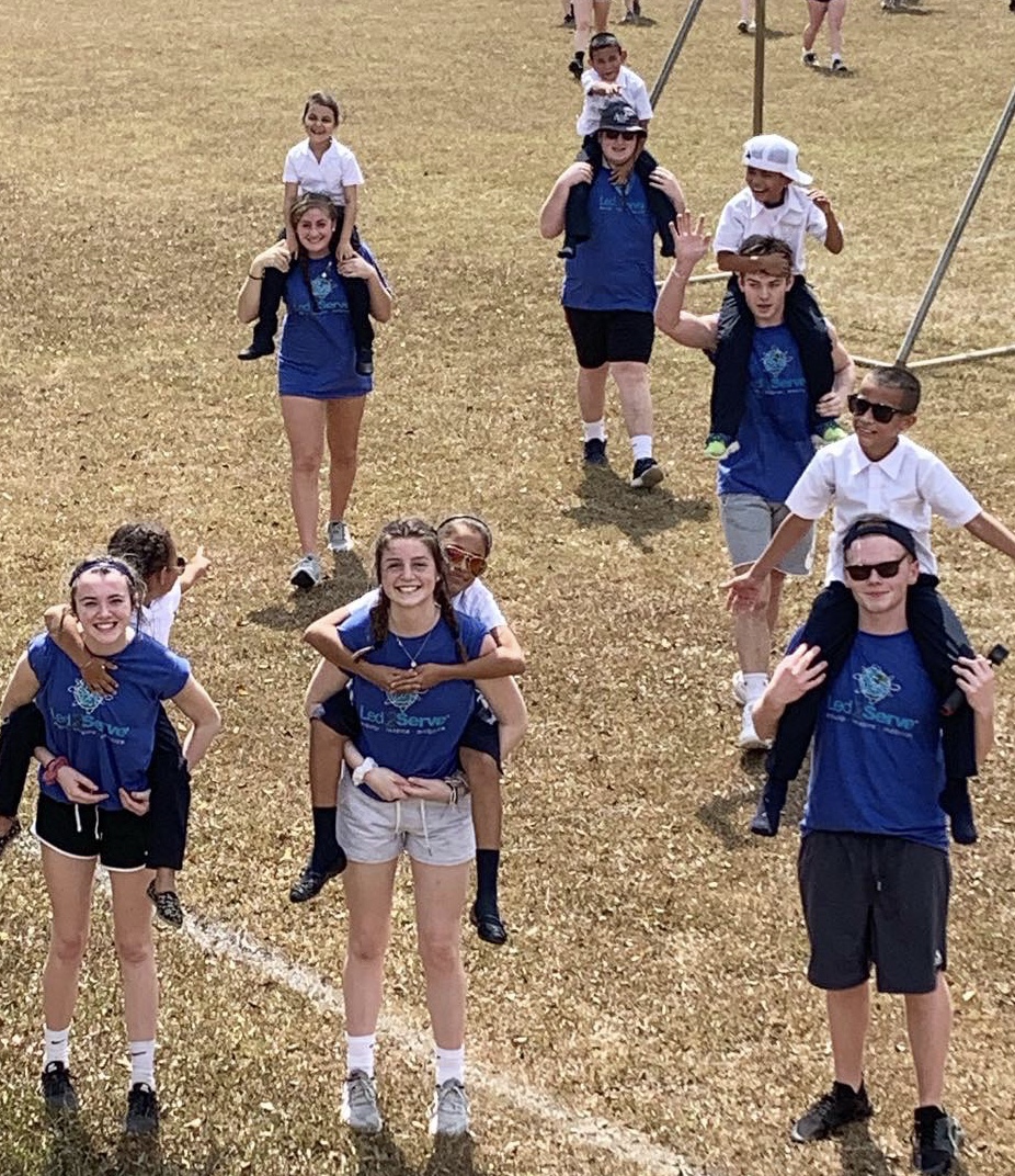 Led2Serve team members carrying children on a Costa Rica service trip