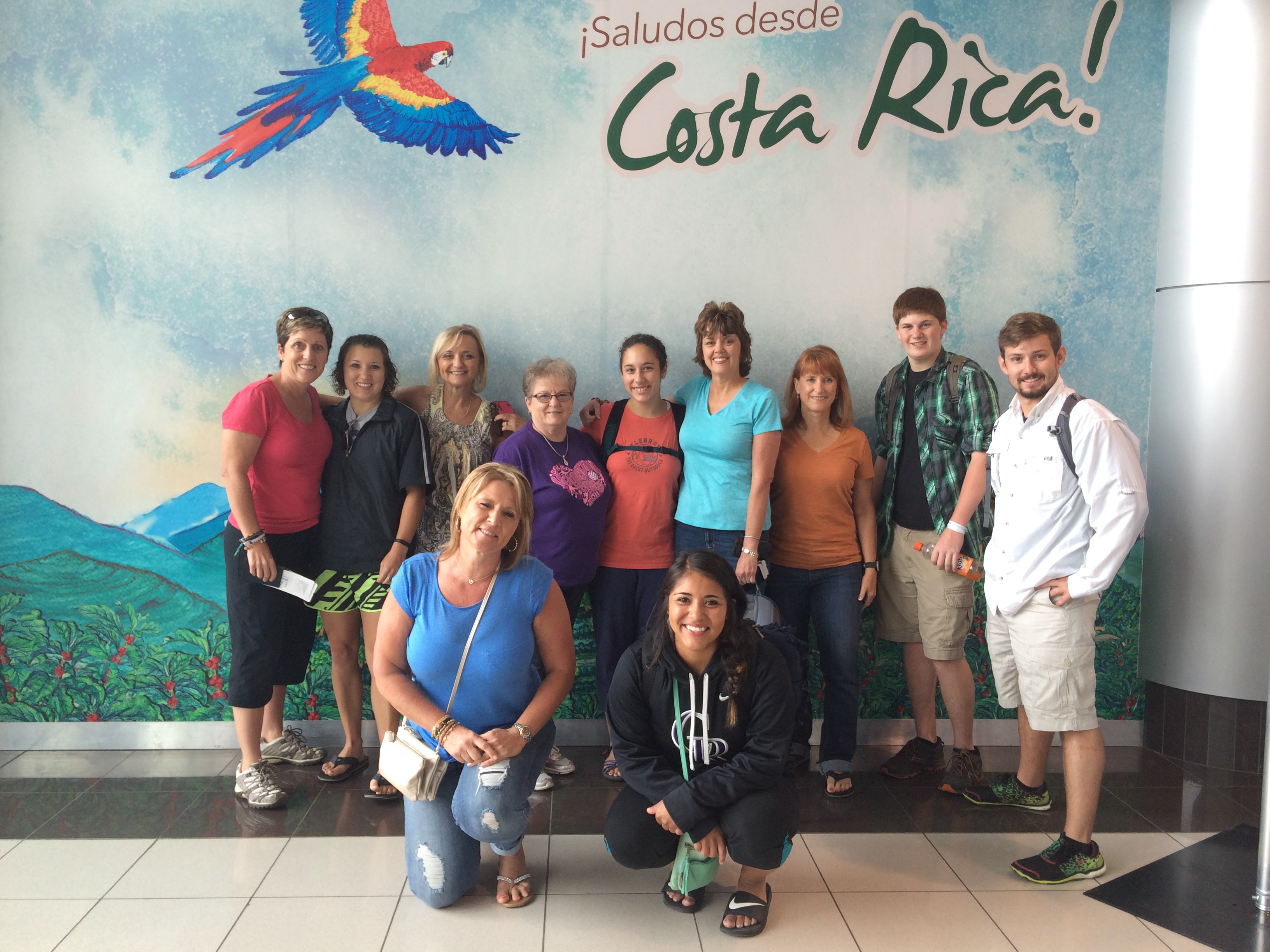 Group of 11 posing in front of a Costa Rica mural