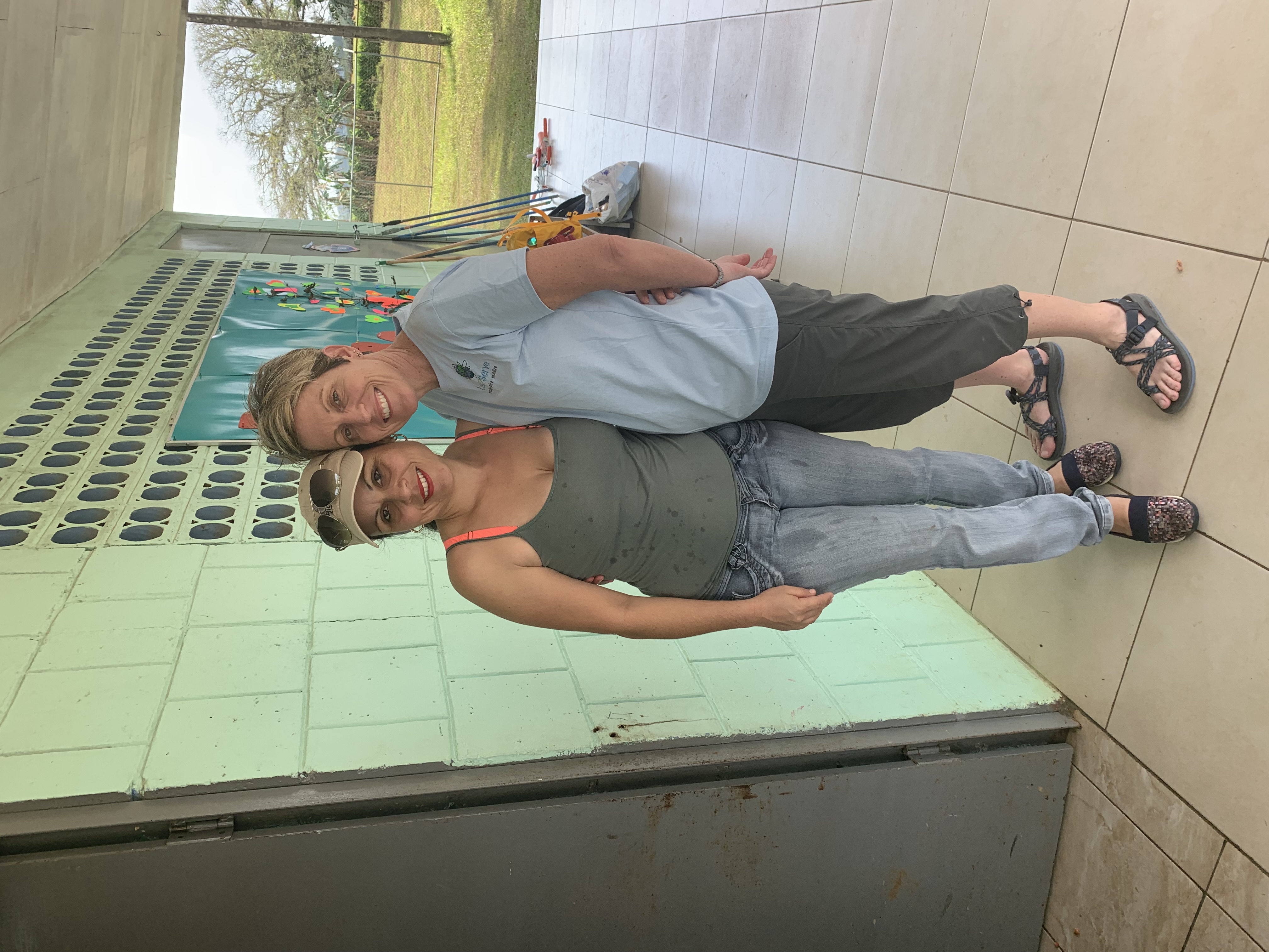 Two women volunteers smiling together on the Koi grounds