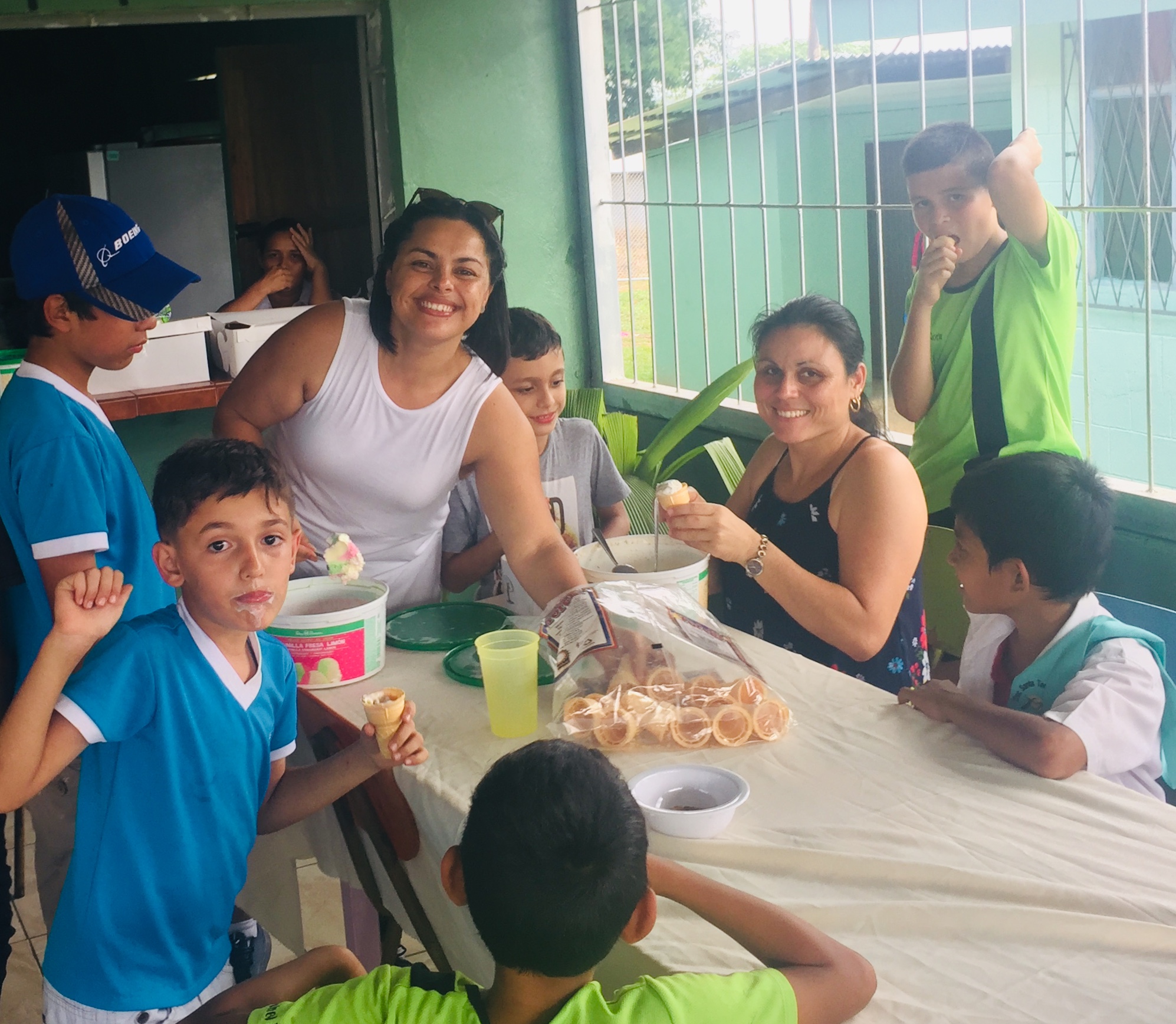 Volunteers sharing ice cream with local children at a community gathering