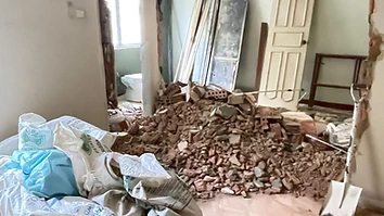 Pile of red brick debris and filled construction waste bags in a Singapore flat after wall hacking works, ready for haulage