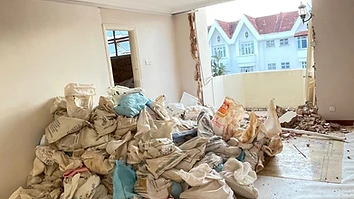 Bagged demolition debris piled in a Singapore flat after hacking works, ready for haulage and disposal