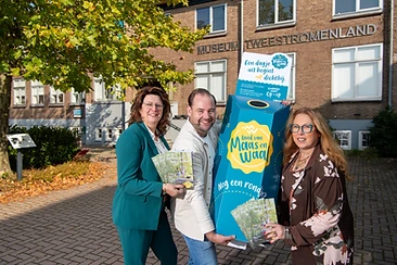 Wethouders en een bewoner bij Museum Twee Stromenland met de grabbelactie-stand van Land van Maas en Waal