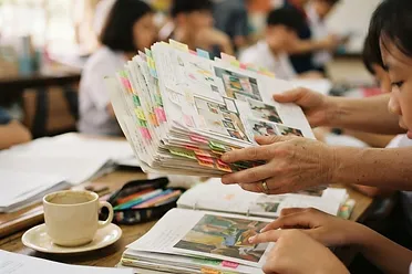 A dossier of a student's real work, held in two hands.