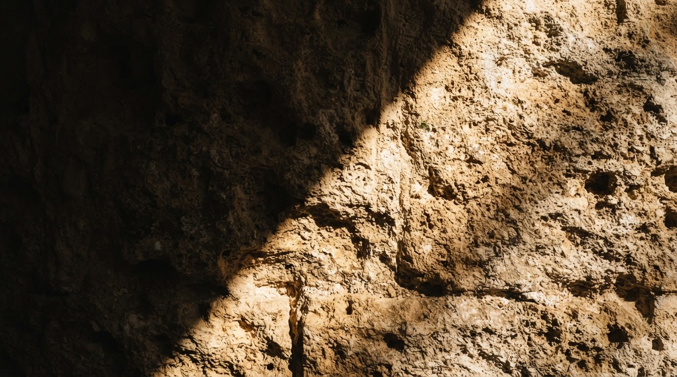 A ray of golden light striking an ancient limestone wall