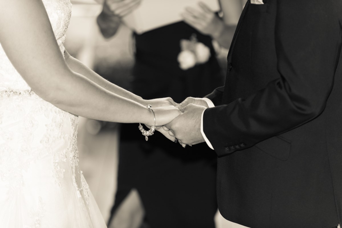 The bride and groom's hands clasped during their ceremony at Hunter Valley Gardens