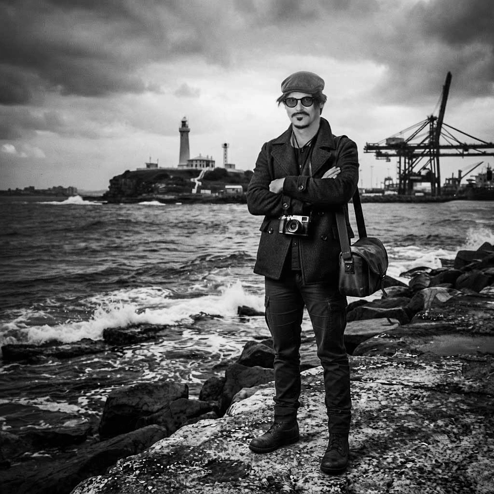 John Adams, Newcastle wedding photographer, on the harbour foreshore with Nobbys lighthouse in the background