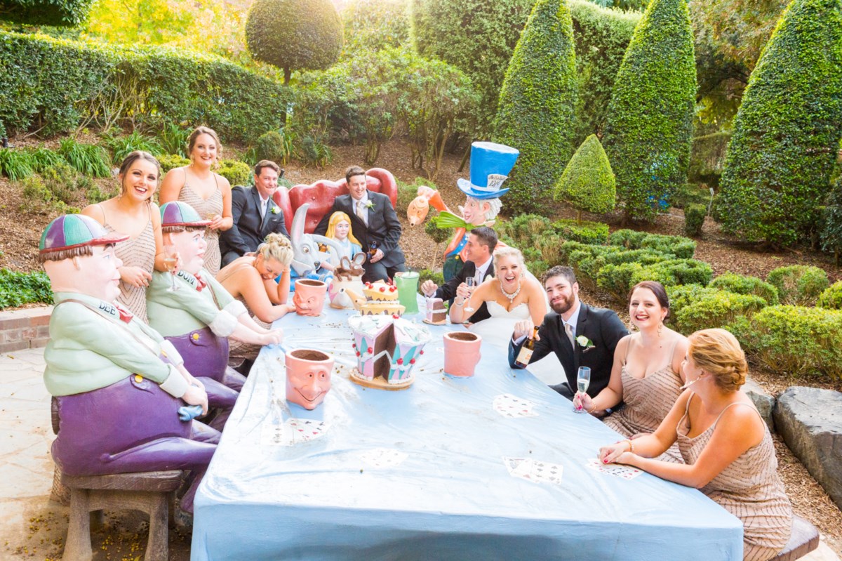 A wedding party seated at the Mad Hatter's Tea Party table in the Storybook Garden at Hunter Valley Gardens