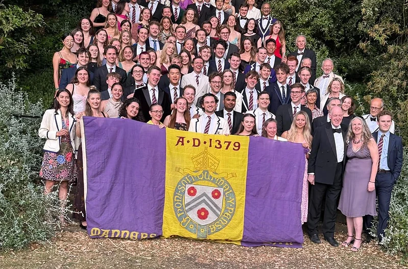 New College Boat Club members gathered with the club flag