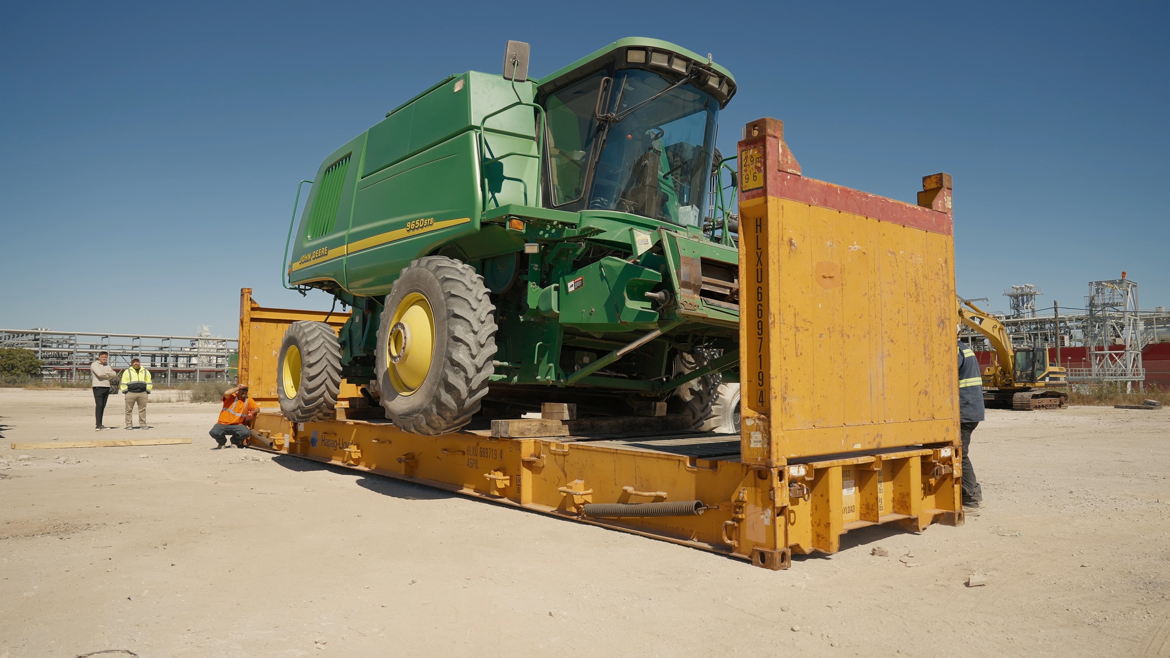 John Deere combine harvester secured on flat-rack container
