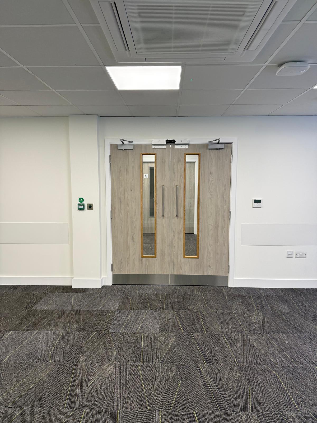 Corridor with double doors and emergency door release call point
