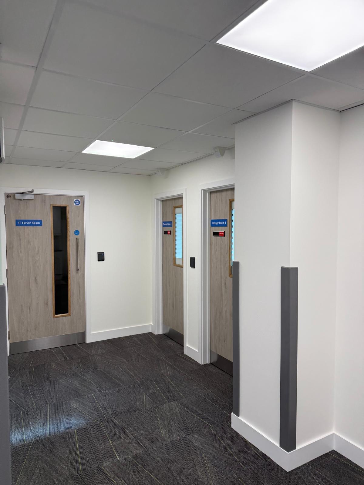 Office corridor with IT Server Room and Therapy Room 2 signage