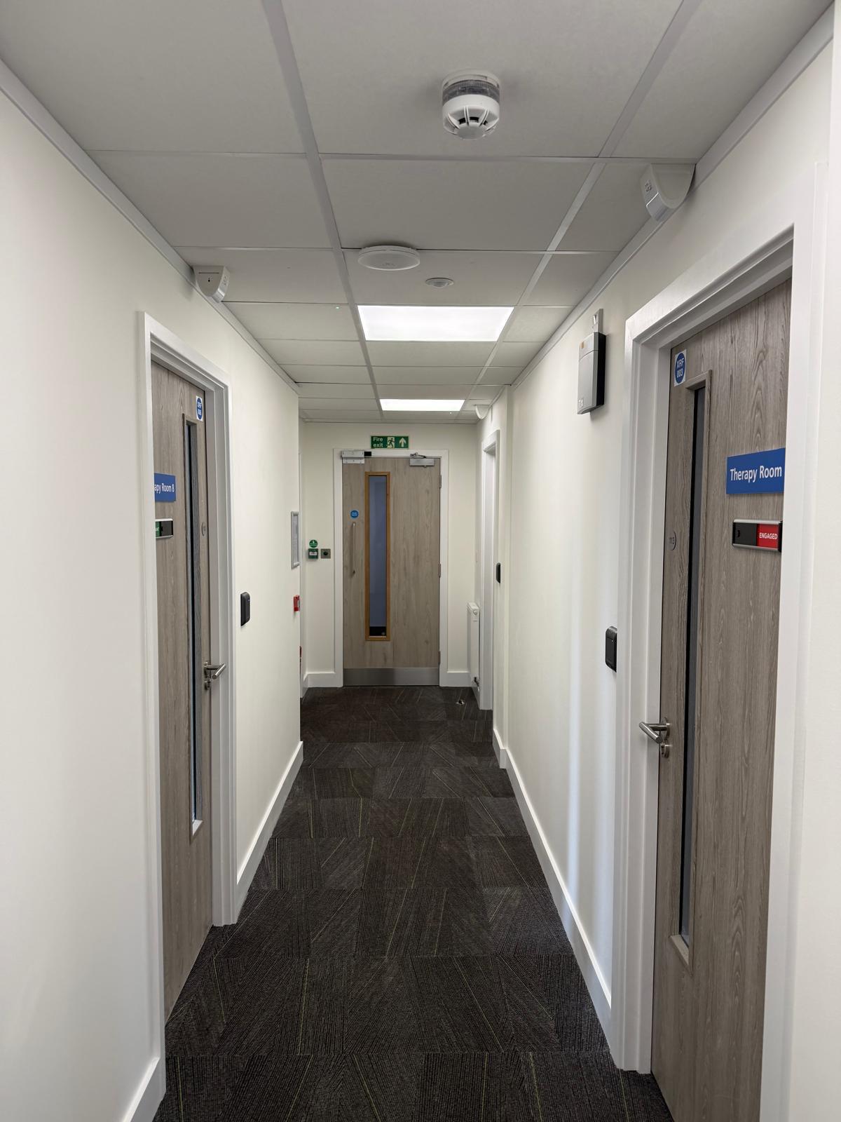 Corridor with Therapy Room doors and ENGAGED indicators
