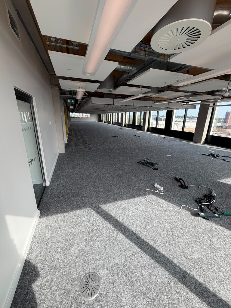 Open plan office floor — ceiling-level cable containment