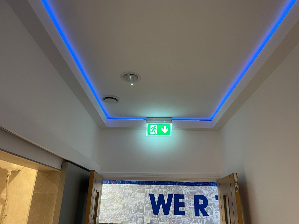 Corridor with blue LED cove lighting and emergency signage