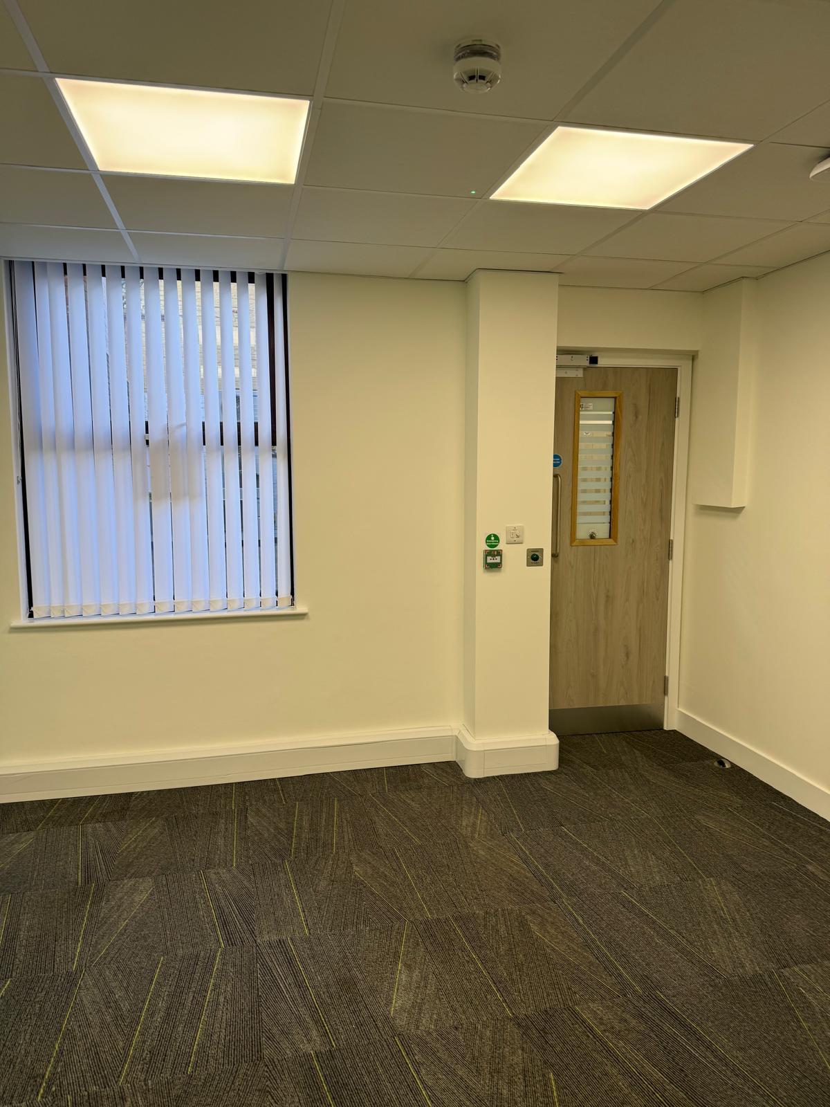 Empty room with fire exit door and emergency release controls