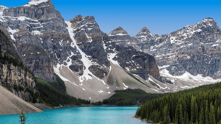 A glacial alpine lake fed by snowmelt, surrounded by snowy Rocky Mountain peaks.