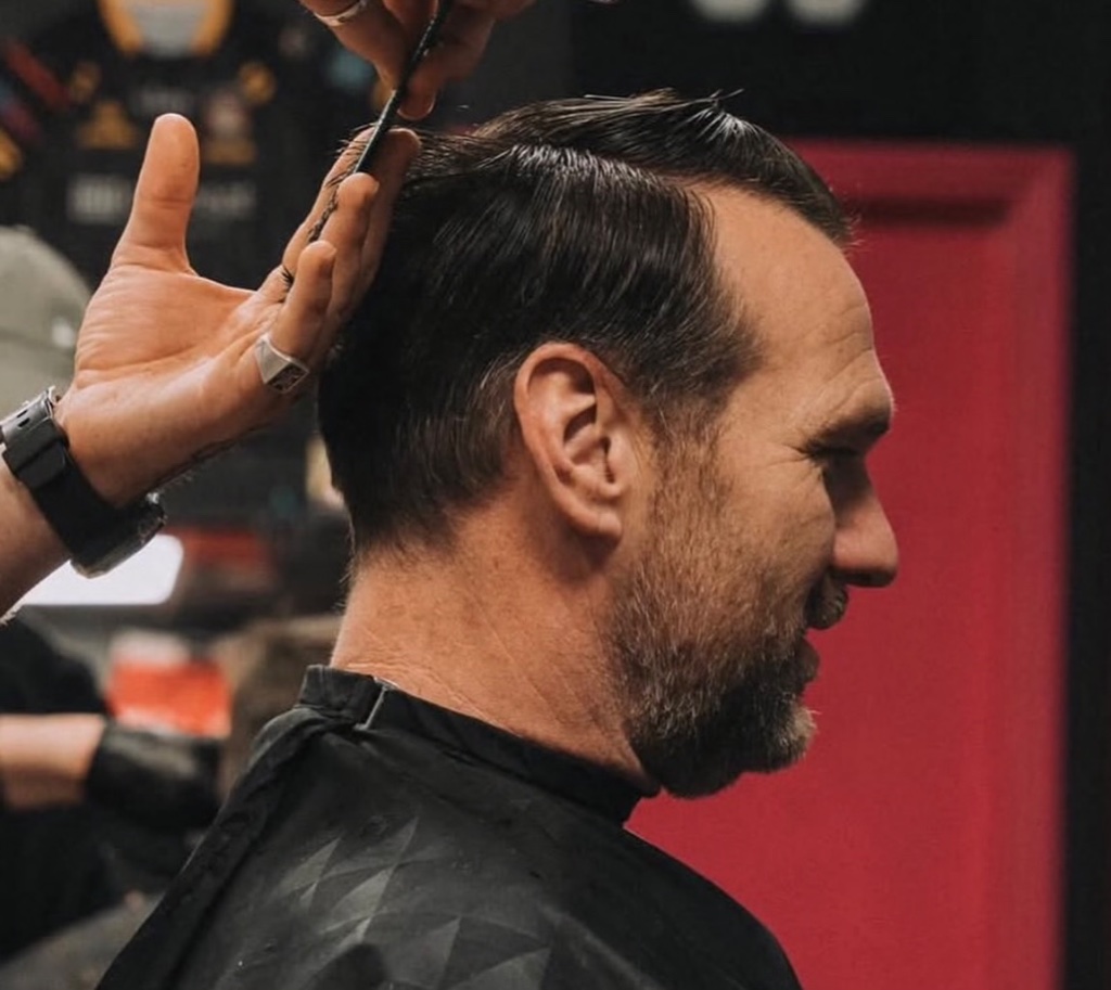 Close-up side profile of comb and scissors haircut in progress