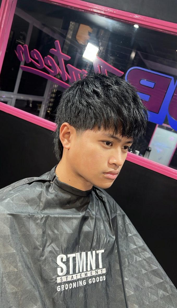 Portrait of a client with dark textured short hair and fade