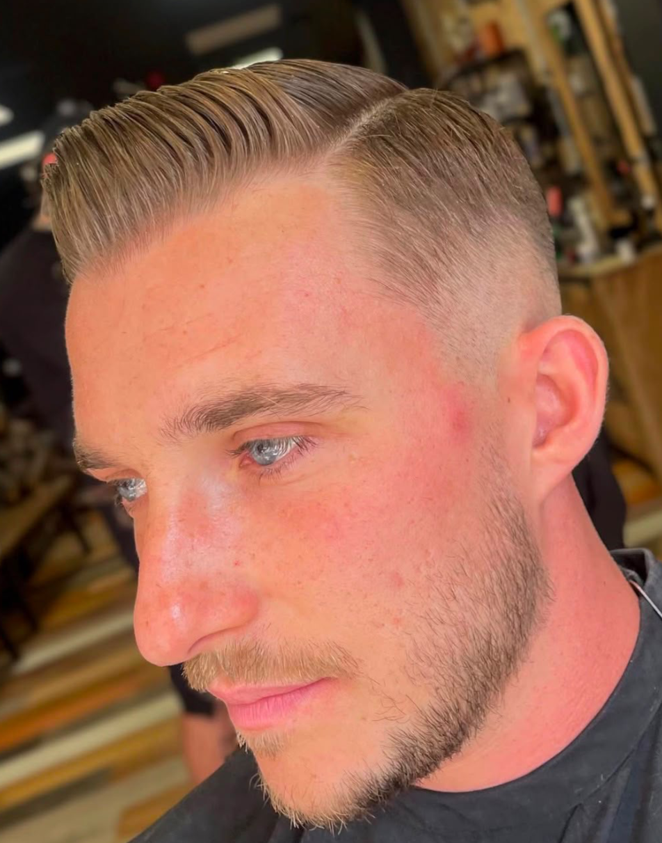 Side-parted skin fade with combed-over top, side profile