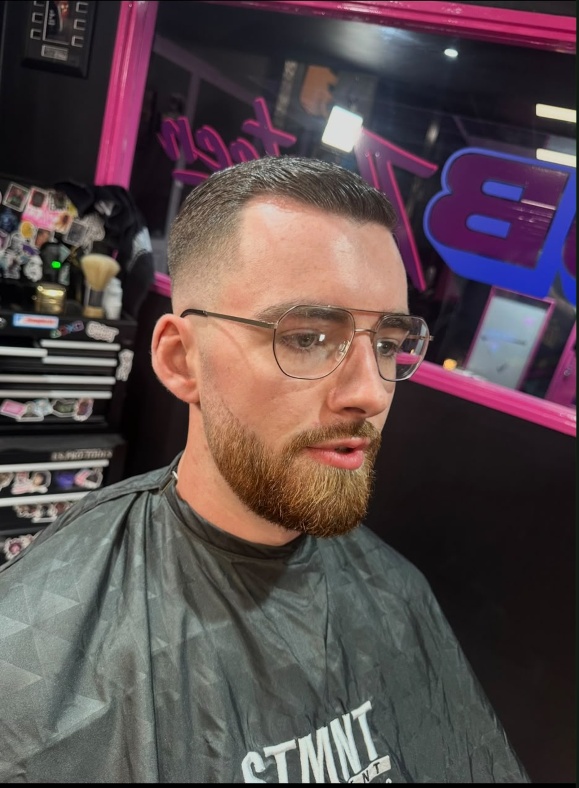 Portrait of a client with a faded haircut, beard and aviator glasses