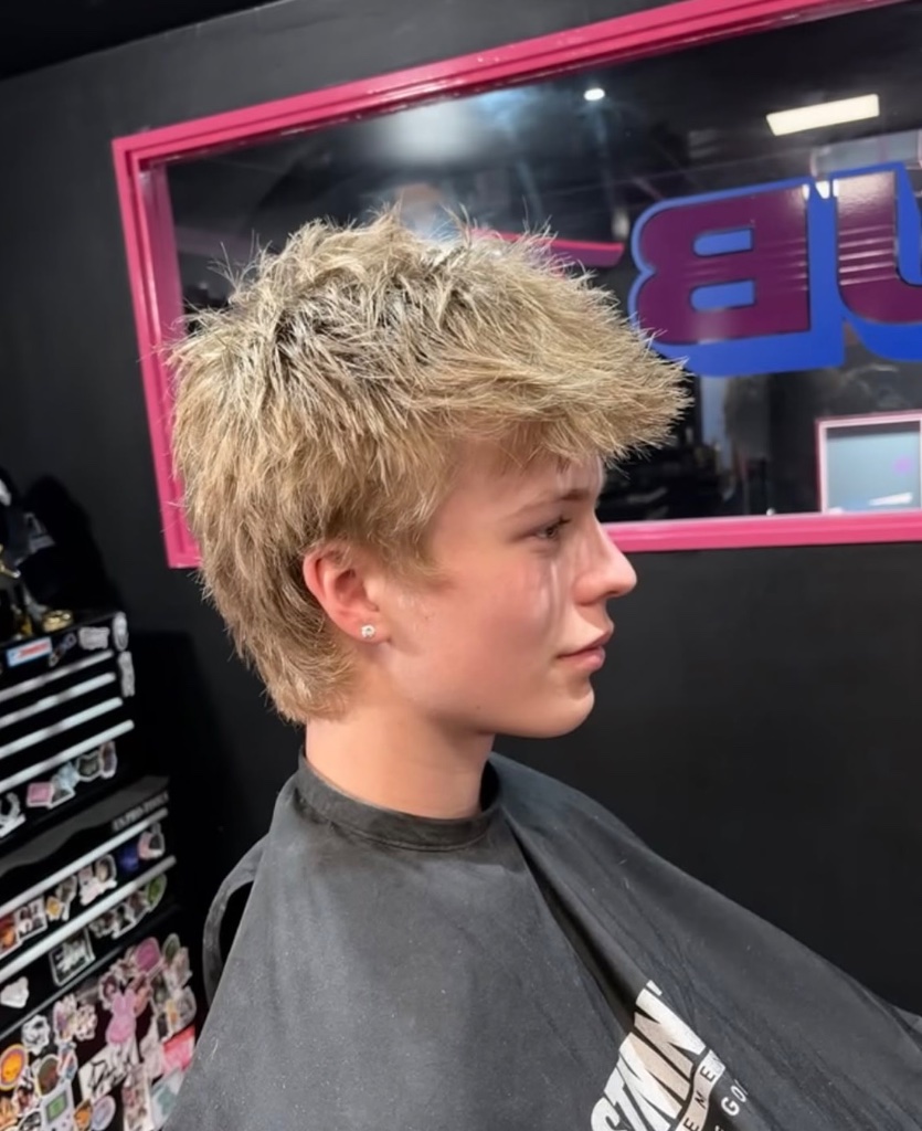 Side profile of blonde textured layered haircut in barber chair