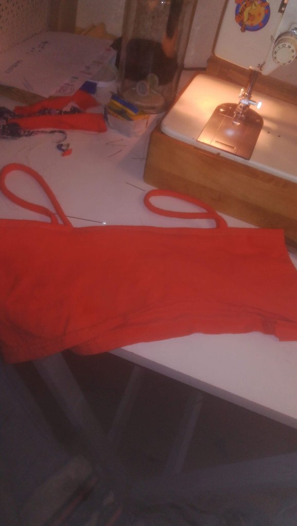 Prenda roja de tirantes finos junto a máquina de coser