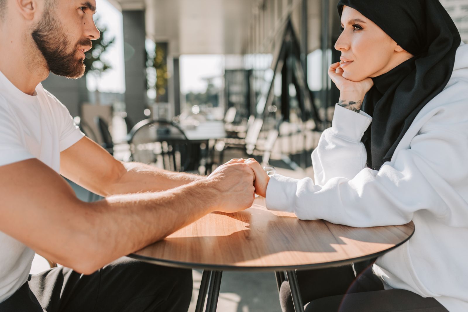 A couple holding hands across a table, talking together