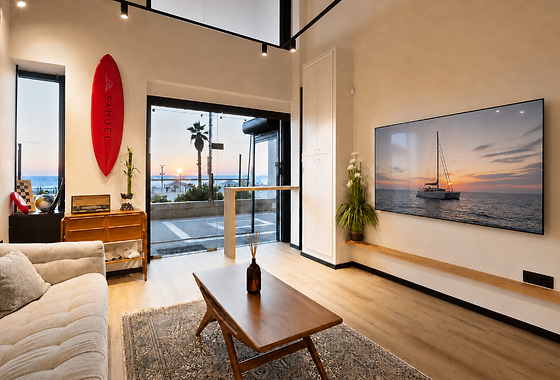 Dining and living space opening onto the beachfront at sunset