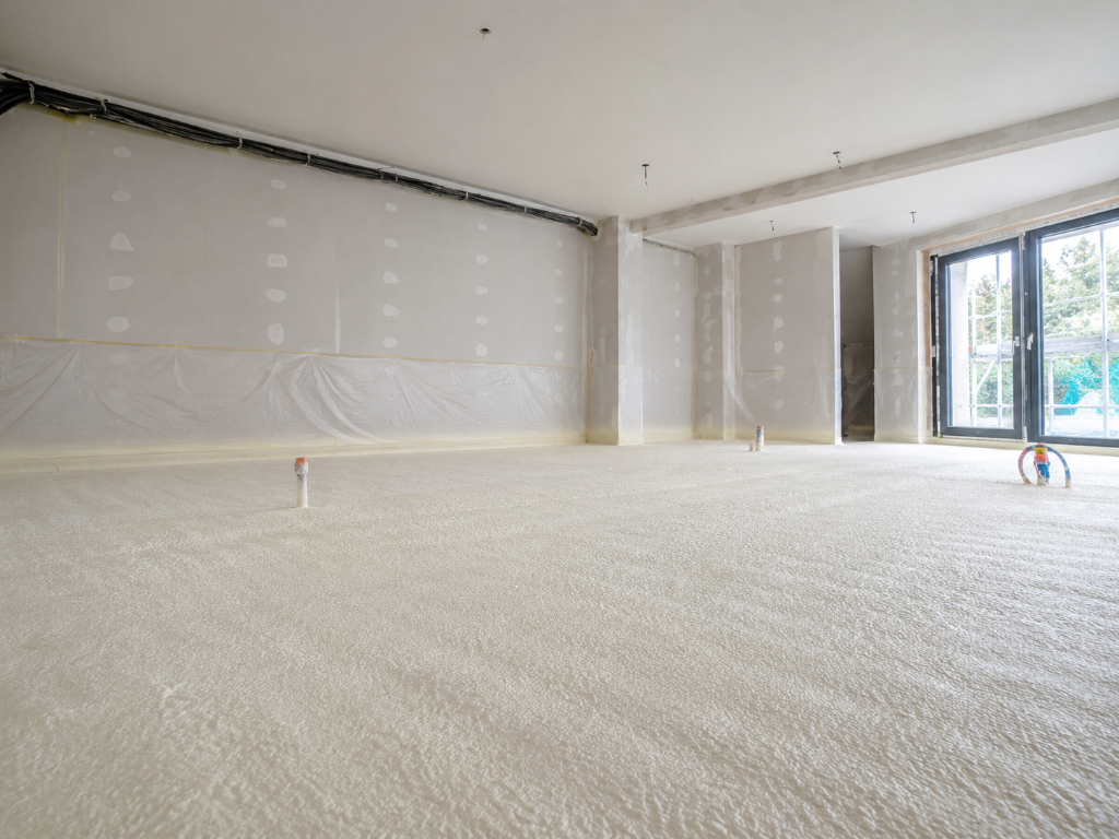 Isolation d'un sol par projection de mousse polyuréthane sur dalle béton dans une maison individuelle