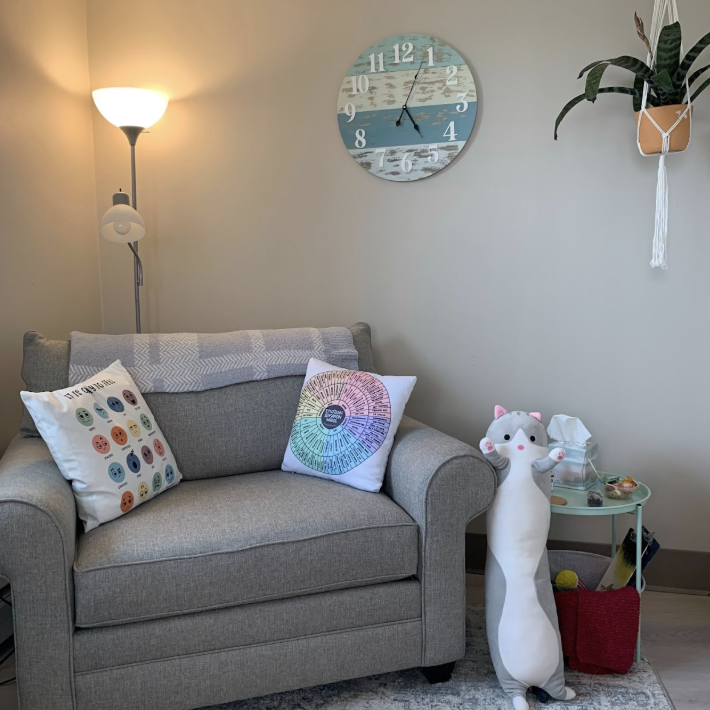 Warm therapy room with sage armchair and natural light
