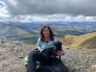 Sarah with her dog Tess on a mountain summit