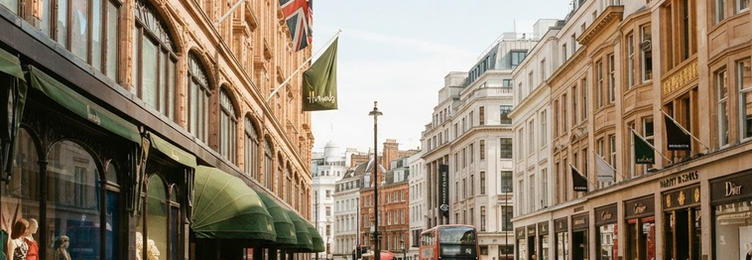 Knightsbridge with luxury boutique storefronts and classical department store architecture in bright natural daylight